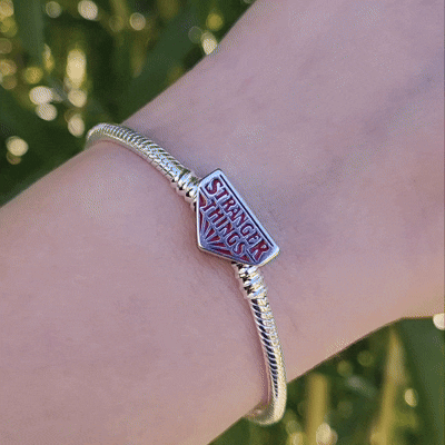 Plongez dans l'univers mystique de Hawkins avec ce bracelet inspiré de Stranger Things. Confectionné en métal noirci et orné de charms iconiques de la série, ce bracelet captivant intègre des symboles uniques comme des ampoules miniatures, la tête du Démogorgon, et le logo du Hellfire Club. Chaque détail soigneusement conçu rappelle les aventures surnaturelles et l'esprit d'amitié qui caractérisent l'histoire. Ce bracelet est un must pour les fans, apportant une note mystique et nostalgique à votre poignet,