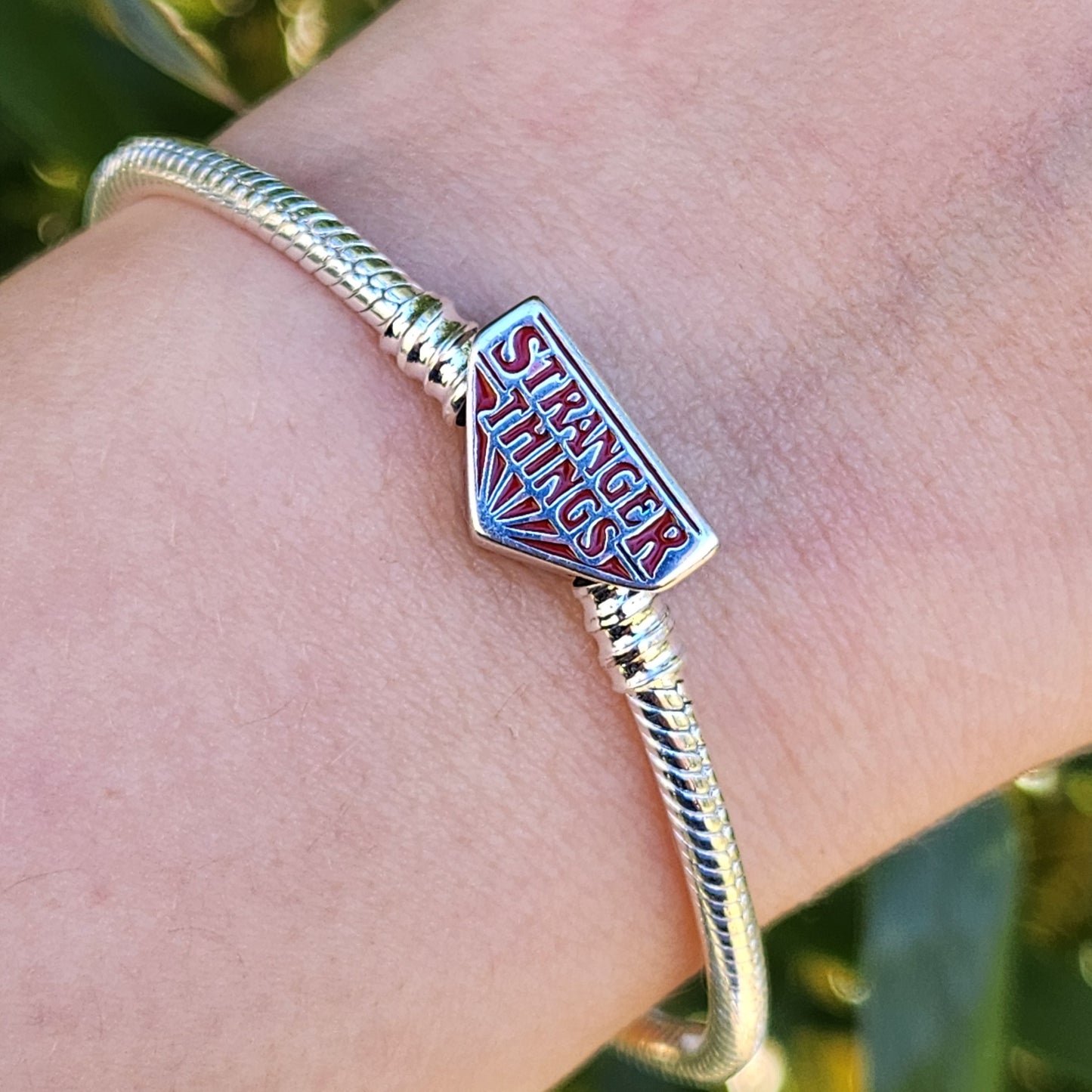 Plongez dans l'univers mystique de Hawkins avec ce bracelet inspiré de Stranger Things. Confectionné en métal noirci et orné de charms iconiques de la série, ce bracelet captivant intègre des symboles uniques comme des ampoules miniatures, la tête du Démogorgon, et le logo du Hellfire Club. Chaque détail soigneusement conçu rappelle les aventures surnaturelles et l'esprit d'amitié qui caractérisent l'histoire. Ce bracelet est un must pour les fans, apportant une note mystique et nostalgique à votre poignet,