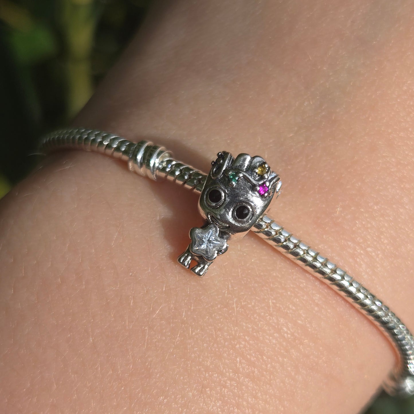 Ajoutez une touche festive et adorable à votre collection avec ce charm Groot en mode Noël. Fabriqué en métal argenté avec des accents de couleur en émail rouge et vert, ce charm représente Groot, le célèbre personnage des Gardiens de la Galaxie, enveloppé dans une guirlande de Noël scintillante, prêt à célébrer les fêtes. Les détails minutieux capturent son expression malicieuse et son côté espiègle, parfait pour les fans de Marvel et de la magie de Noël. Compatible avec les bracelets Pandora, ce charm uni