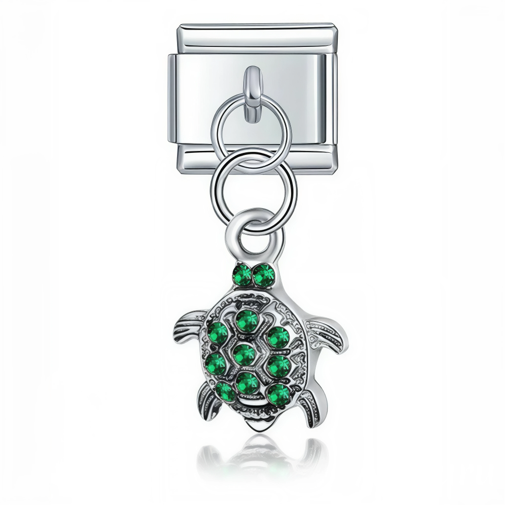 Ce charm italien pendentif représente une tortue délicate ornée de strass verts scintillants, symbole de longévité et de nature. Fabriqué en acier inoxydable de haute qualité avec une finition argentée élégante, il allie robustesse et finesse des détails pour un rendu raffiné et lumineux. Facile à fixer, il s’adapte parfaitement à nos bracelets composés de 17 maillons extensibles et réglables, convenant à toutes les tailles de poignet. Compatible avec tous nos charms italiens, ce bijou étincelant est idéal