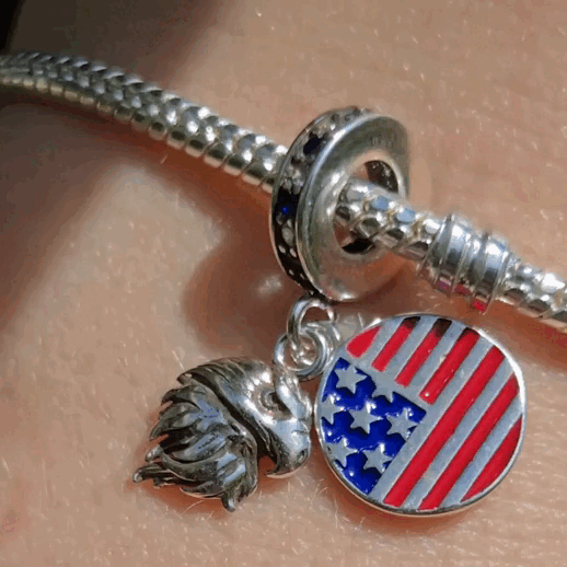 Affichez fièrement les symboles de la liberté et du patriotisme avec le Charm - Aigle et Drapeau des États-Unis, en argent sterling S925. Ce charm combine la majesté de l'aigle, emblème national américain, et les étoiles et rayures du célèbre drapeau des États-Unis. Idéal pour les voyageurs, les amoureux de la culture américaine ou ceux qui souhaitent porter un symbole de fierté et de force.