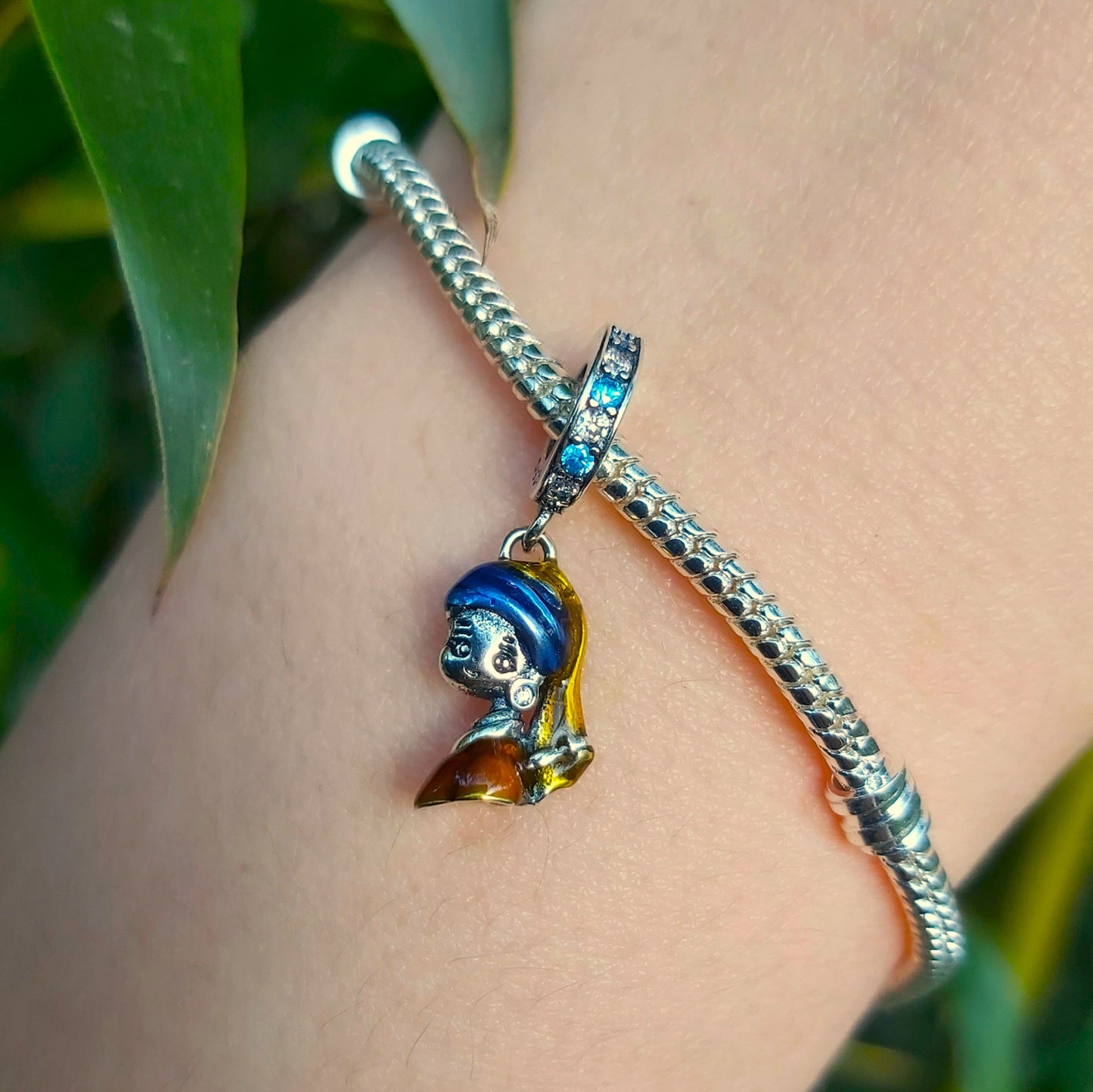 Incarnez l'élégance artistique avec ce Charm - La Jeune Fille à la Perle, en argent sterling S925. Inspiré du célèbre tableau de Vermeer, ce charm est un hommage à la beauté intemporelle et à la délicatesse de cette œuvre d'art emblématique. Parfait pour les amateurs d'art et de culture, ce charm ajoute une touche de raffinement et de mystère à votre collection.