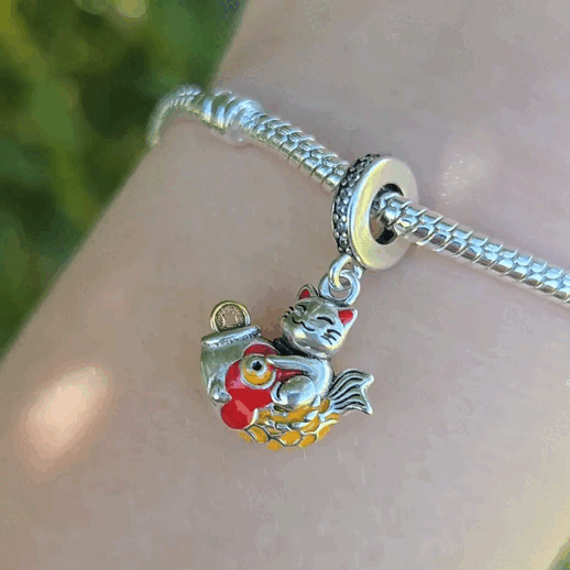 Invitez la chance et la prospérité dans votre vie avec ce charm inspiré du célèbre Maneki Neko, le chat porte-bonheur japonais. Fabriqué en argent sterling S925, ce charm représente le Maneki Neko levant la patte, symbole d'accueil de la fortune et du bonheur. Détail parfait pour célébrer le Nouvel An chinois ou tout autre événement festif. Ce charm élégant est compatible avec les bracelets Pandora et ajoutera une touche unique et porteuse de sens à votre collection.