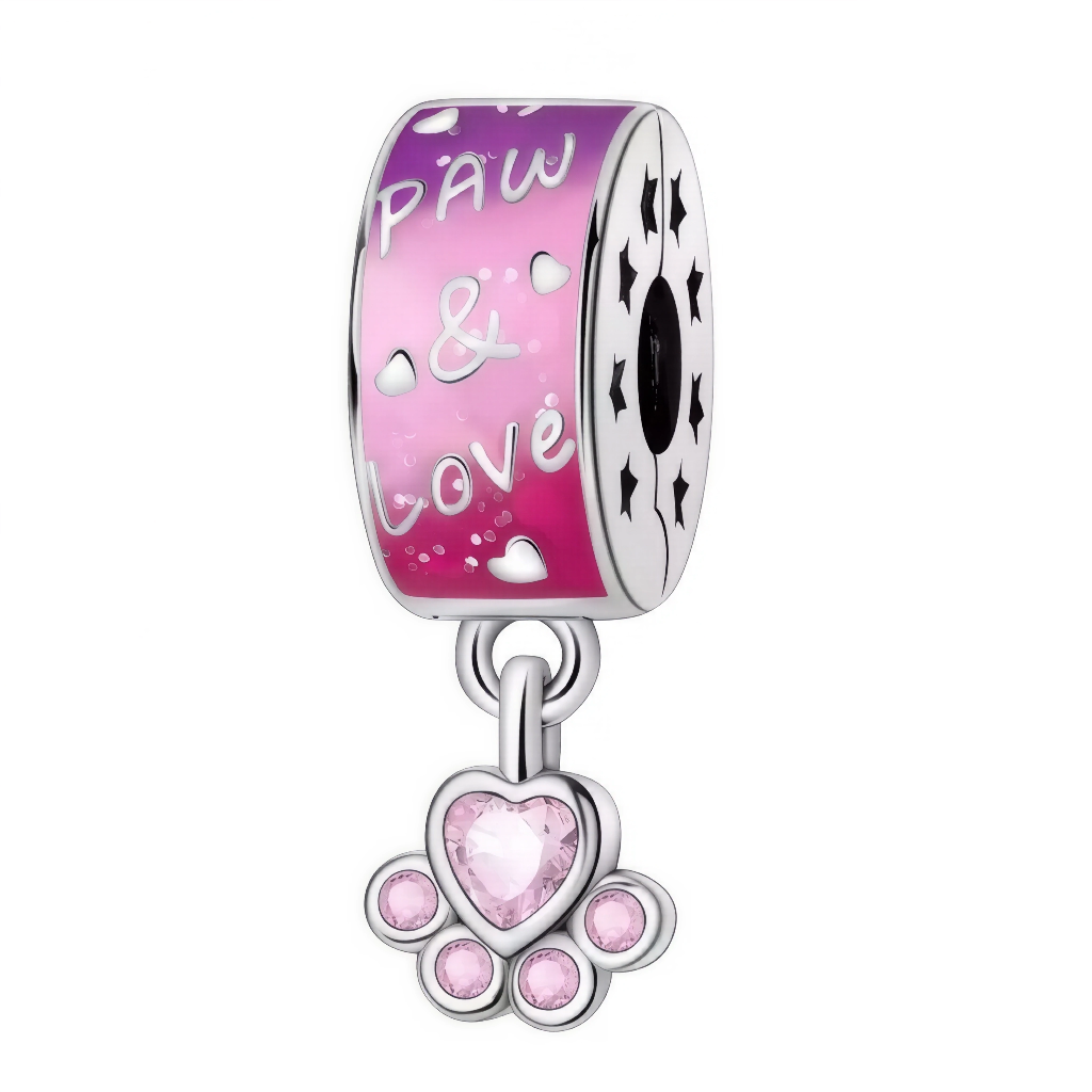 Ce charm exprime la passion pour nos compagnons à quatre pattes : sur le cylindre laqué d’un rose vif sont gravés des petits cœurs, l’inscription « Paw et& Love » et des étoiles perforées sur la tranche. En dessous pend une ravissante patte ornée de pierres roses, dont un cristal central en forme de cœur. Idéal pour personnaliser le bracelet d’un amoureux des animaux ou marquer un joli message d’amitié fidèle.