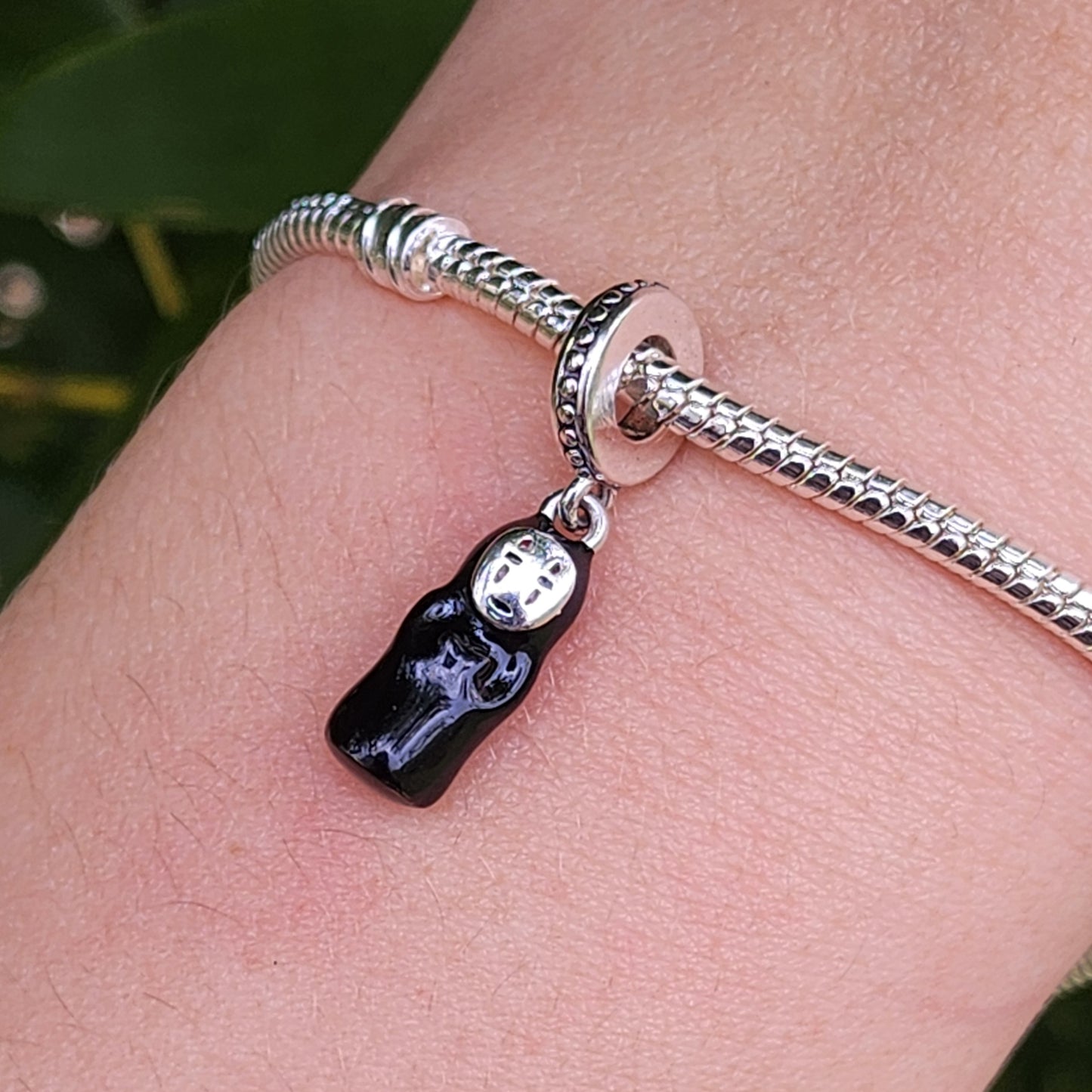 Invitez la magie du Voyage de Chihiro dans votre collection avec ce charm Sans Visage. En argent 925, il reflète le mystère et l’élégance de cet énigmatique personnage du chef-d’œuvre de Miyazaki.