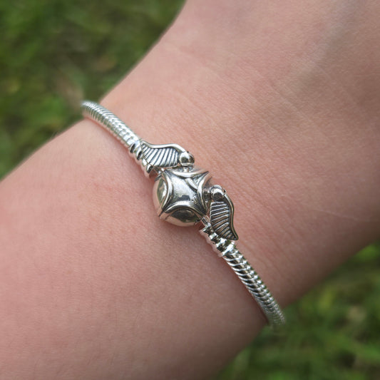 Ajoutez une touche de magie et d'aventure à votre collection avec ce bracelet inspiré par l'univers de Harry Potter. Fabriqué avec des matériaux de haute qualité, ce bracelet allie confort et design enchanteur, capturant l'essence de la célèbre saga magique. Parfait pour les fans de Harry Potter et les amateurs de bijoux à thème, ce bracelet est orné de détails emblématiques comme le symbole des Reliques de la Mort, le scarabée de Poudlard, et d'autres éléments magiques, ajoutant une note de charme et de my