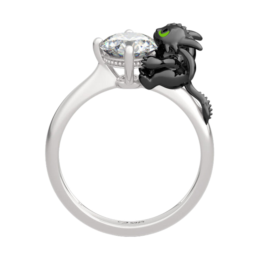 Affirme ton style avec cette bague sensationnelle inspirée de Krokmou, le dragon emblématique du film “Dragons”. Sculpté dans une posture câline autour d’une pierre centrale lumineuse, ce bijou marie avec talent la puissance de la créature légendaire et le raffinement de l’argent 925.
L’émail noir profond souligne les courbes de Krokmou tandis que son regard vert vif apporte une touche de magie à ce modèle unique. Parfaite pour les passionnés de l’univers DreamWorks, cette bague originale accompagnera chaqu