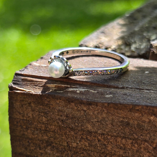 Plongez dans l'univers magique d'Ariel, la princesse sirène de La Petite Sirène, avec cette bague argentée ornée d'une perle. Fabriquée en argent 925, cette bague sublime une perle qui symbolise la mer, la beauté sous-marine et l'élégance intemporelle de la princesse. Ce design délicat et raffiné vous permet de porter un morceau du monde sous-marin d'Ariel, tout en célébrant son esprit libre et son amour pour l'aventure.