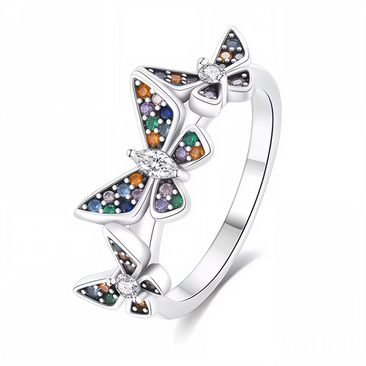 Apportez une touche de poésie et de couleur à votre style avec cette bague en argent 925 ornée de trois papillons aux ailes scintillantes. Chaque papillon brille de teintes multicolores pour un effet lumineux et raffiné. Un bijou idéal pour celles qui aiment les designs délicats et enchanteurs.