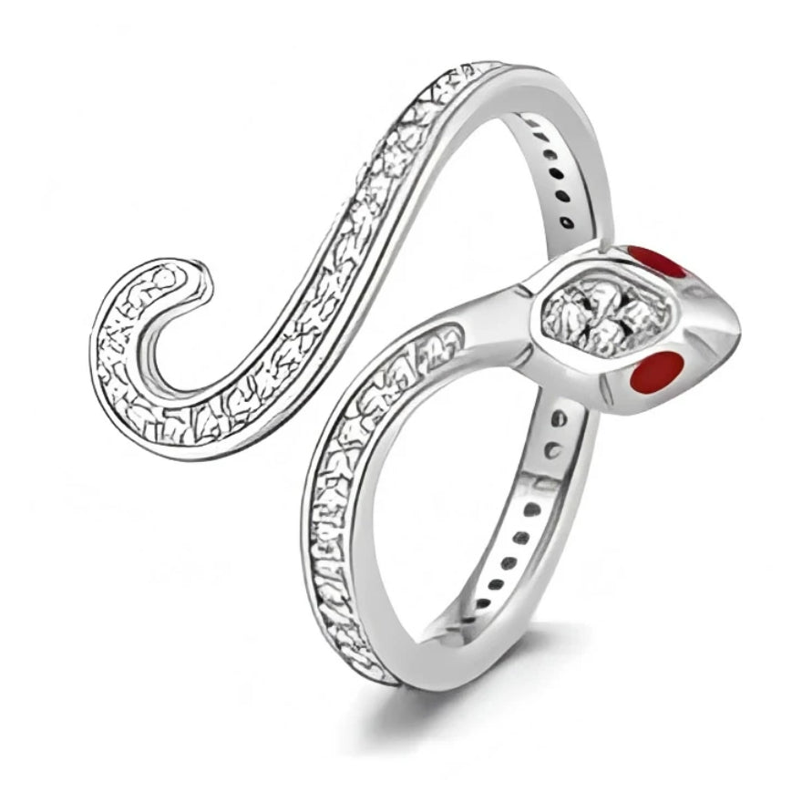 Cette bague en argent 925 dessine la silhouette d’un serpent qui s’enroule autour du doigt, avec un anneau fin prolongé par une longue queue ouverte et courbée, entièrement sertie de petits cristaux scintillants. La tête du serpent, mise en avant, est ornée d’un cristal central facetté et de deux touches d’émail rouge pour figurer les yeux, donnant un look à la fois élégant et mystérieux.

Caractéristiques :
Matière : Argent 925/1000 (sterling silver) avec incrustation de cristaux clairs et détails d’émail 