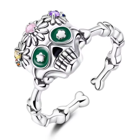Affirmez votre style avec cette bague en argent 925 inspirée de l’univers festif du Día de los Muertos. Son design de tête de mort finement travaillé, décoré de motifs colorés et floraux, en fait un bijou original et plein de caractère. Parfait pour celles et ceux qui aiment les accessoires audacieux et symboliques.