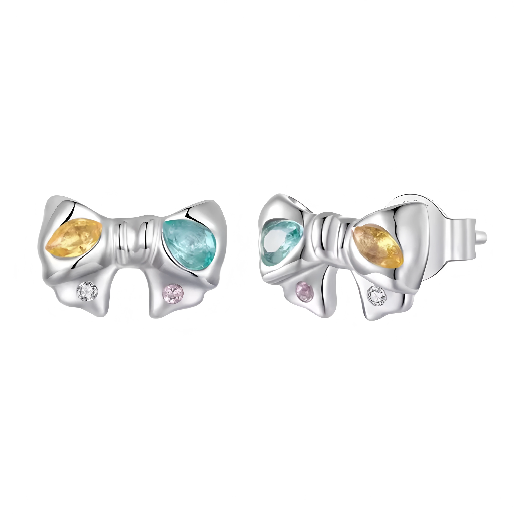 Ces boucles d’oreilles puces adoptent la forme d’un élégant nœud en argent 925, orné de pierres colorées façon gouttes de pluie pastel. Une pierre jaune lumineuse et une pierre bleu lagon en taille navette illuminent chaque extrémité du nœud, tandis que deux petits cristaux ronds rose et blanc ajoutent une touche délicate et féminine. Leur format compact en fait un bijou raffiné à porter au quotidien ou pour sublimer une tenue de fête avec une discrète note de couleur.