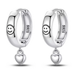 Ces boucles d’oreilles créoles en argent 925 affichent un petit smiley gravé sur le devant et un cœur lisse pendant à chaque anneau. Elles diffusent une touche de bonne humeur et de tendresse, parfaites pour illuminer le quotidien avec un détail fun et délicat.

Caractéristiques :

-Matière : Argent 925/1000 massif, finition brillante, conçu pour être léger, résistant et agréable à porter tous les jours.
-Design : Créoles épaisses et lisses ornées d’un motif smiley discret sur la face avant, retenant un pet