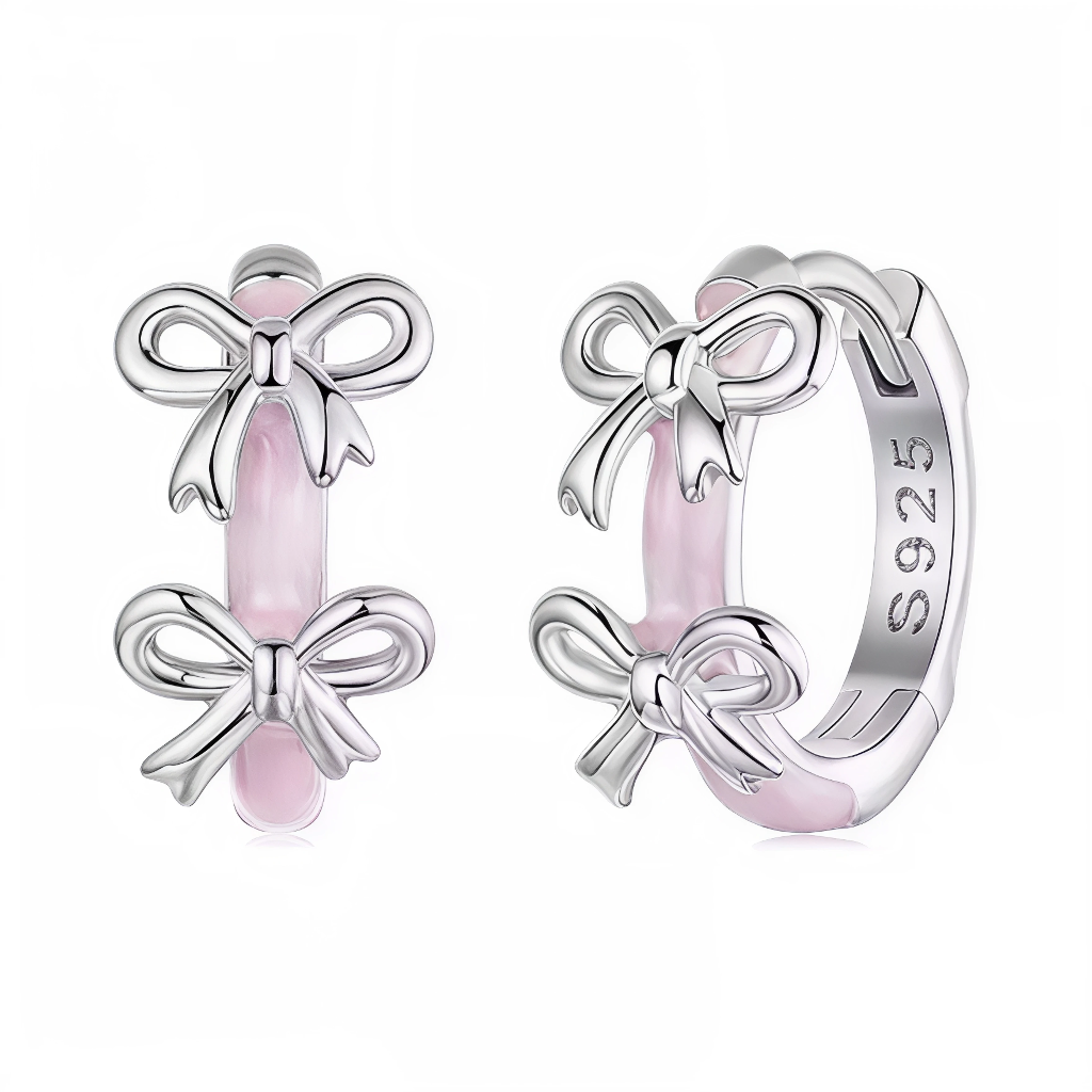 Ces créoles fines sont habillées d’un bandeau d’émail rose tendre, sur lequel viennent se poser plusieurs nœuds ruban en argent poli, rappelant le symbole d’Octobre Rose. Leur design délicat et féminin permet de porter un message de soutien et de solidarité au quotidien, tout en restant élégant et discret. Une paire idéale pour les campagnes de sensibilisation, les événements caritatifs ou comme cadeau pour honorer un combat ou une rémission.