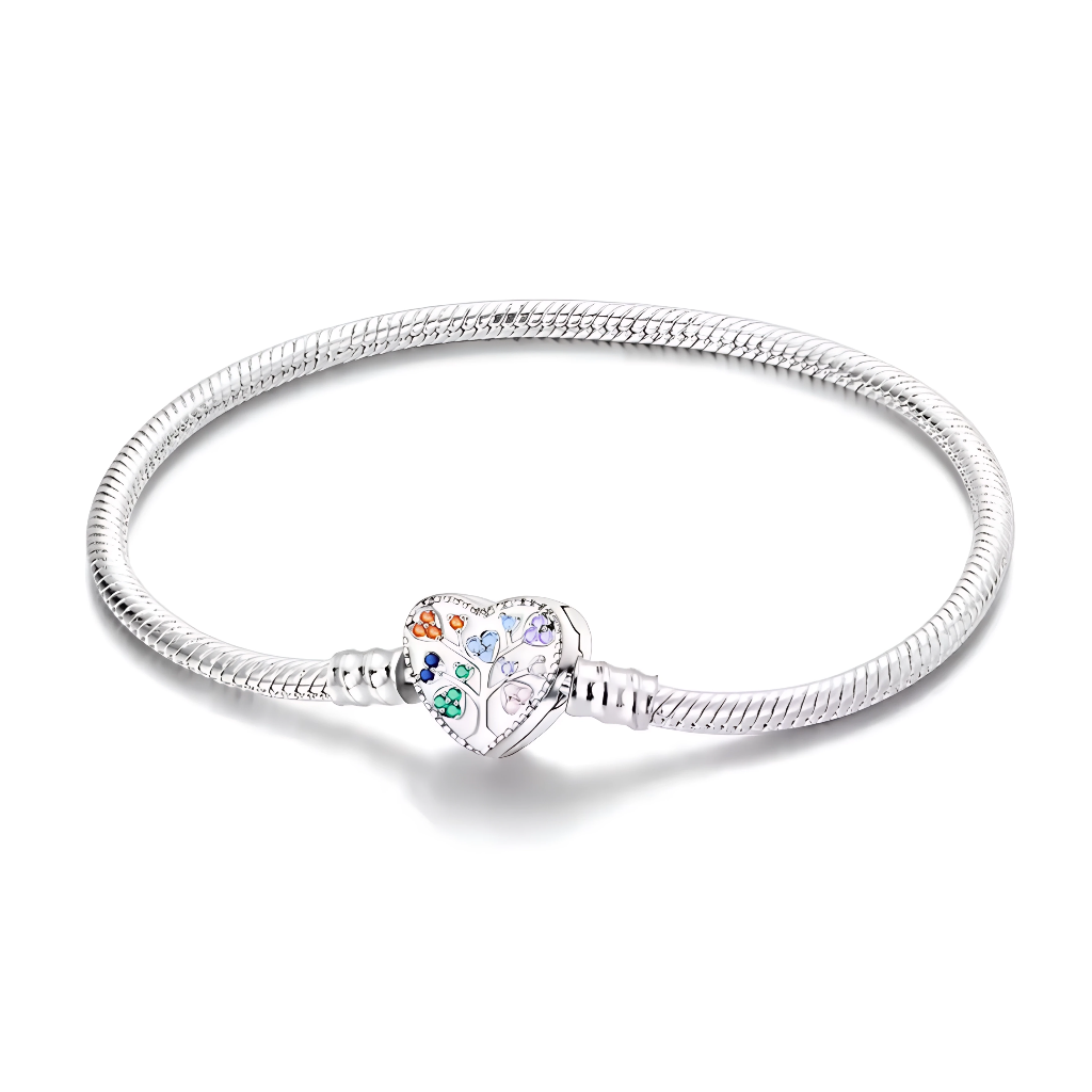 Ce bracelet en argent 925 est orné d’un fermoir en forme de cœur décoré d’un arbre de vie stylisé, dont les feuilles sont représentées par de petites pierres colorées évoquant les membres de la famille.
Il symbolise les liens qui unissent votre clan et se porte seul ou avec des charms de type européen pour créer un bijou chargé de sens.