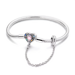 Ce bracelet en argent 925 est orné d’un fermoir en forme de cœur vintage, serti d’une pierre rose au centre et entouré de cristaux aux couleurs de l’arc‑en‑ciel pour un rendu lumineux et féminin.
La chaîne de sécurité reliée à un anneau lisse sécurise vos charms tout en ajoutant un joli mouvement au poignet, parfait pour un bijou à porter tous les jours.