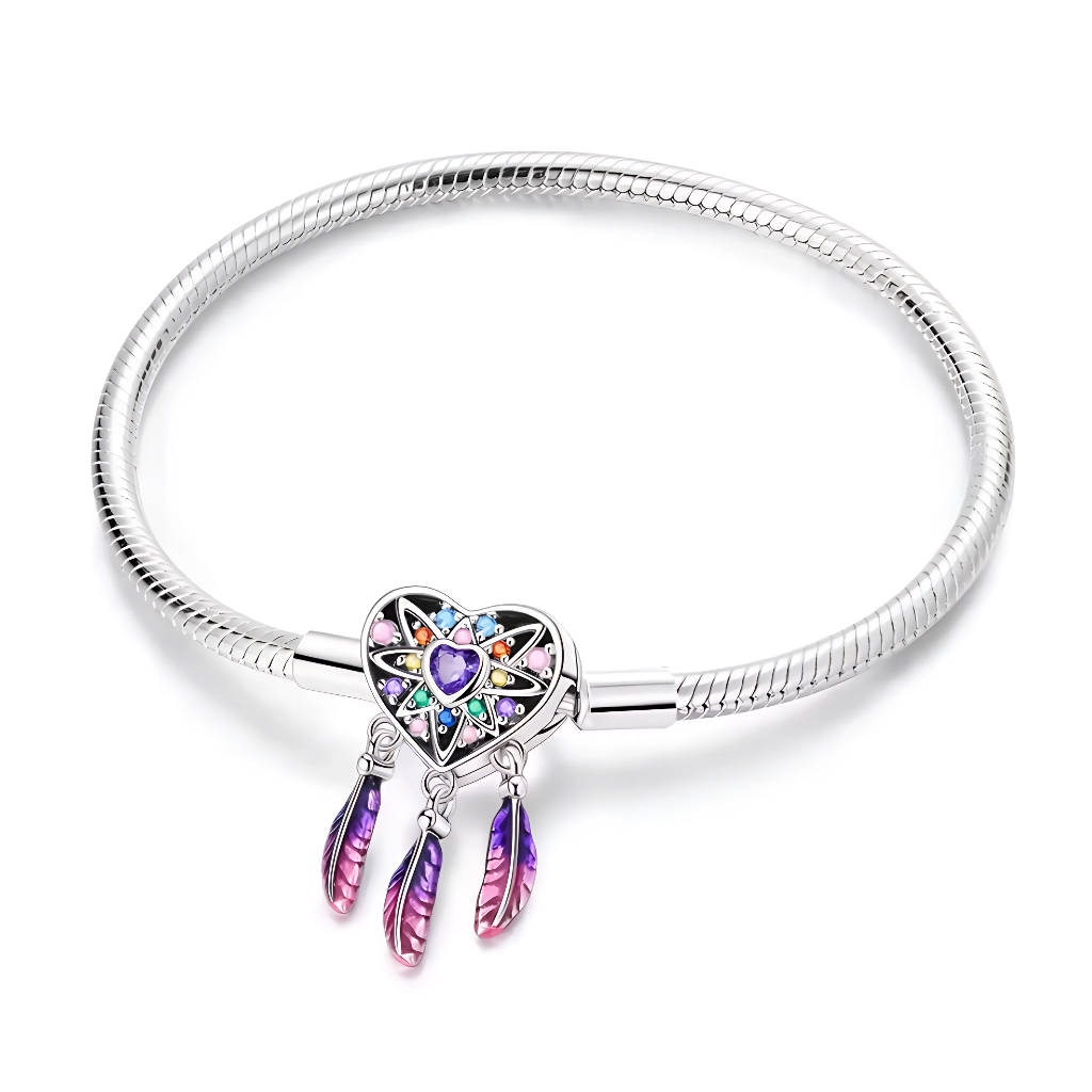 Ce bracelet en argent 925 présente un fermoir en forme de cœur façon attrape‑rêves, orné d’un cœur central violet et de petits cristaux multicolores qui dessinent une étoile lumineuse.
Trois plumes émaillées dans un joli dégradé mauve‑rose se balancent sous le fermoir, apportant une touche bohème et poétique au poignet.