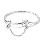 Ce bracelet en argent 925 est orné d’un fermoir en forme de cœur gravé « FOREVER », souligné d’un petit cristal central, qui symbolise un amour éternel.
Une chaîne de sécurité assortie, décorée d’un charm infini, protège vos charms tout en apportant une touche romantique supplémentaire au poignet.