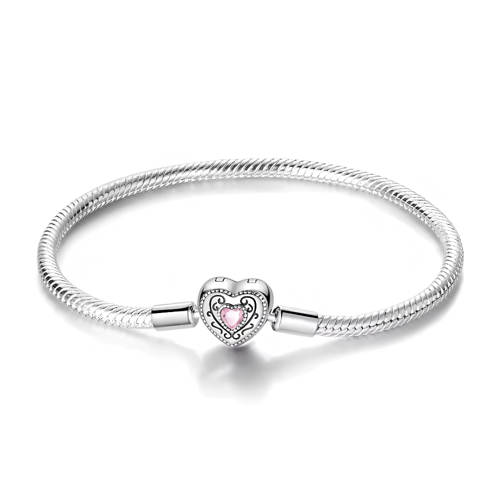 Ce bracelet en argent 925 présente un fermoir cœur bombé au contour perlé, orné d’arabesques délicates qui encadrent une pierre rose taille cœur pour un rendu romantique.
Son style baroque et féminin en fait une base idéale pour composer un bracelet de charms sentimental ou pour se porter seul comme bijou d’exception.