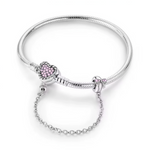Ce bracelet en argent 925 est orné d’un fermoir cœur texturé, serti de petites pierres roses qui lui donnent un aspect tendre et romantique.
Une chaîne de sécurité élégante, attachée à un charm nœud décoré de cristaux roses, protège vos charms tout en ajoutant un détail raffiné au poignet.