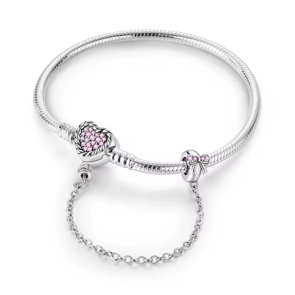 Ce bracelet en argent 925 est orné d’un fermoir cœur texturé, serti de petites pierres roses qui lui donnent un aspect tendre et romantique.
Une chaîne de sécurité élégante, attachée à un charm nœud décoré de cristaux roses, protège vos charms tout en ajoutant un détail raffiné au poignet.