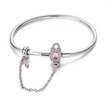 Ce bracelet en argent 925 est orné d’un fermoir cadenas rectangulaire, serti de zircones claires et d’une pierre rose facettée qui symbolise un amour bien gardé.
Une chaîne de sécurité délicate reliée à un anneau stoppeur se termine par une mini clé décorée d’un cœur rose, pour sécuriser vos charms avec élégance.