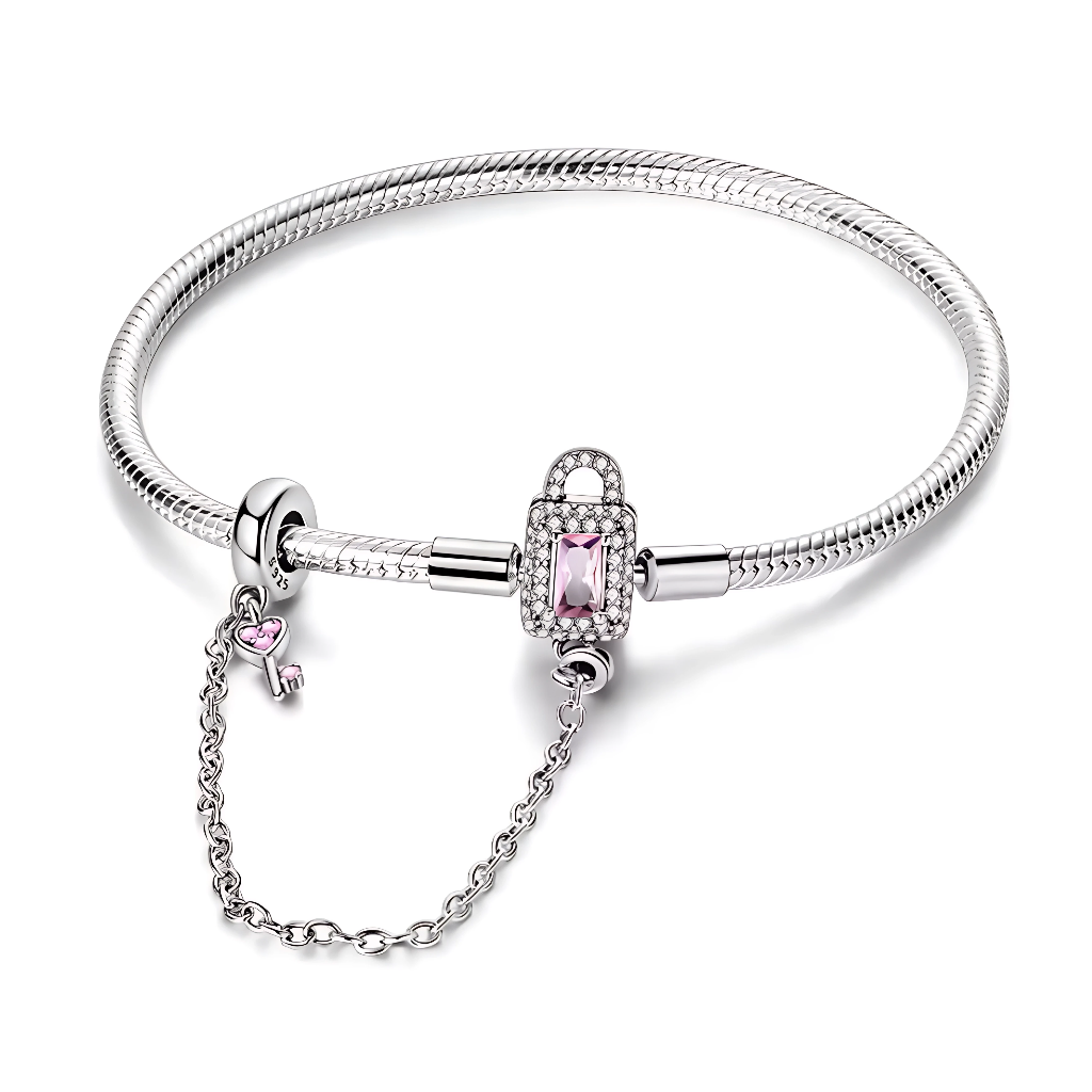 Ce bracelet en argent 925 est orné d’un fermoir cadenas rectangulaire, serti de zircones claires et d’une pierre rose facettée qui symbolise un amour bien gardé.
Une chaîne de sécurité délicate reliée à un anneau stoppeur se termine par une mini clé décorée d’un cœur rose, pour sécuriser vos charms avec élégance.
