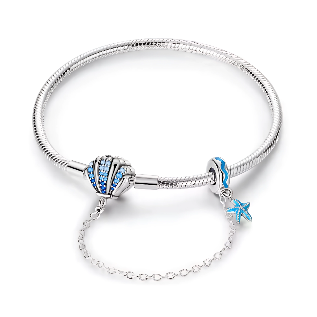 Ce bracelet en argent 925 évoque les vacances au bord de l’océan avec son fermoir coquillage serti de pierres bleues et sa chaîne de sécurité ornée d’une étoile de mer émaillée.
Il se porte seul pour un style marin chic ou comme base à charms de type européen pour composer un univers plage, été et bord de mer.