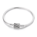 Ce bracelet en argent 925 se distingue par son fermoir barillet travaillé de stries obliques qui rappellent un motif de feuille, souligné par une rangée de zircones étincelantes.
Il offre une base élégante et moderne pour accueillir vos charms de type européen ou se porter seul pour un look minimaliste mais sophistiqué.