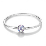 Ce bracelet en argent 925 présente un élégant fermoir sphérique orné de fleurs scintillantes dans des nuances bleues et violettes, pour une touche romantique et lumineuse au poignet.
Il peut se porter seul pour un look épuré ou servir de base à charms de type européen pour créer un bijou personnalisé.