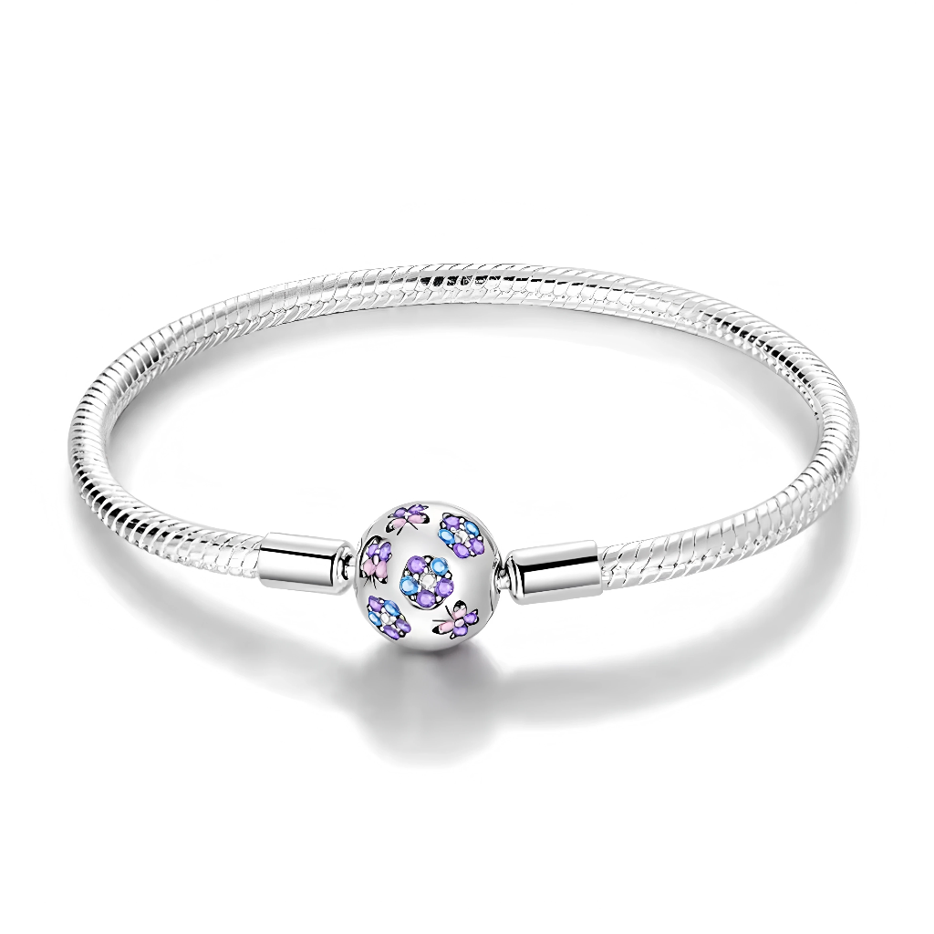 Ce bracelet en argent 925 présente un élégant fermoir sphérique orné de fleurs scintillantes dans des nuances bleues et violettes, pour une touche romantique et lumineuse au poignet.
Il peut se porter seul pour un look épuré ou servir de base à charms de type européen pour créer un bijou personnalisé.
