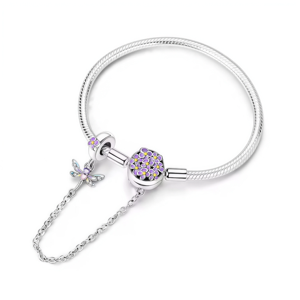 Ce bracelet en argent 925 est orné d’un fermoir disque recouvert de minuscules fleurs émaillées violettes au cœur jaune, pour un rendu doux et printanier.
La chaîne de sécurité, attachée à un anneau décoré d’une fleur, se termine par une délicate libellule multicolore qui apporte mouvement et poésie au poignet.