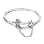 Ce bracelet en argent 925 est doté d’un fermoir en forme de main de Fatma finement ajourée, rehaussée d’un cristal bleu central façon œil protecteur, symbole de chance et de protection.
La chaîne de sécurité intégrée, reliée à un anneau décoré de petits cristaux bleus, sécurise vos charms tout en ajoutant une touche élégante au poignet.