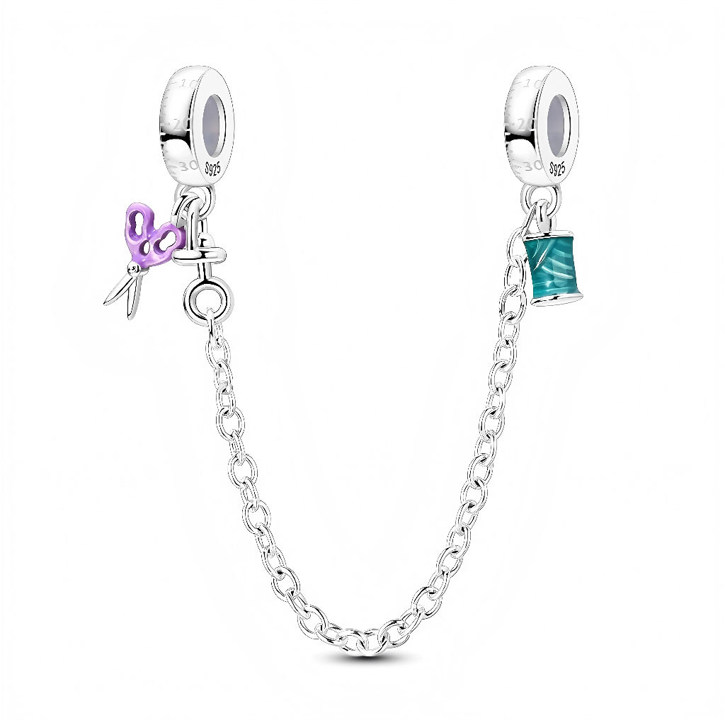 Cette chaîne de sécurité en&nbsp;argent&nbsp;925 met à l’honneur la couture avec deux stoppeurs lisses, reliés par une chaîne maille ronde, décorés d’une paire de ciseaux violets d’un côté et d’une bobine de fil turquoise de l’autre.