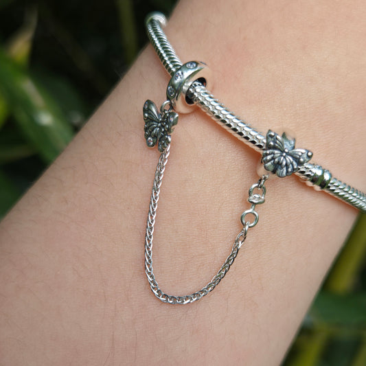 Apportez une touche de légèreté et de liberté à votre bracelet avec cette magnifique chaîne de sécurité ornée de deux papillons. Fabriquée en argent 925, cette chaîne présente deux papillons finement sculptés, symbolisant la transformation et la beauté fragile de la nature. Les détails délicats des ailes capturent l'élégance et la grâce de ces créatures volantes.

En plus d’ajouter une note poétique et élégante à votre bijou, cette chaîne de sécurité protège votre bracelet en empêchant les ouvertures accide