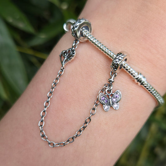 Ajoutez une touche de beauté naturelle et de transformation à votre bracelet avec cette magnifique chaîne de sécurité ornée d’un papillon violet et d’un arbre. Fabriquée en argent 925, cette chaîne combine la délicatesse d’un papillon aux ailes violettes et la force d’un arbre majestueux, symbolisant la liberté, la croissance et l’harmonie avec la nature.

En plus d’ajouter une touche poétique et pleine de sens à votre bijou, cette chaîne de sécurité protège votre bracelet en empêchant les ouvertures accide
