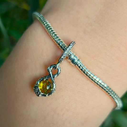 Ajoutez une touche de raffinement à votre collection avec ce charm subtilement inspiré de Belle, l’icône intemporelle de La Belle et la Bête. Sa teinte jaune éclatante rappelle la douceur et l’élégance de la célèbre princesse, tandis que sa forme évoque une pierre précieuse, symbole de lumière et de force intérieure. Fabriqué en argent 925 et sublimé par une finition soignée, ce bijou apportera une note lumineuse et enchanteresse à votre bracelet ou collier.