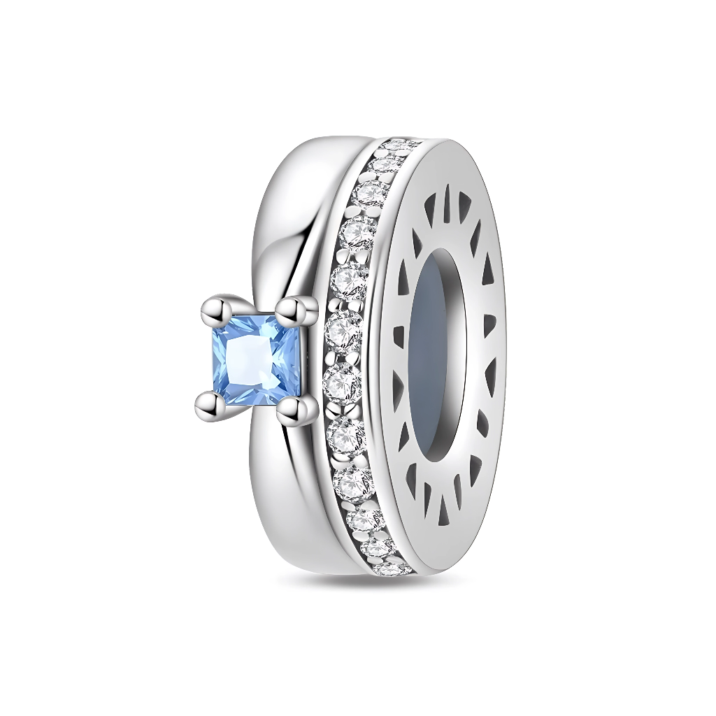 Ce charm séparateur en argent 925 adopte la forme d’un petit anneau brillant, souligné sur une face par une rangée de zircons transparents sertis serrés. Sur le côté, une pierre carrée bleu ciel est montée en serti griffes, apportant une touche de couleur élégante et lumineuse.

Caractéristiques :

-Matière : Argent 925 avec zirconia transparents et pierre synthétique bleue.
-Design : Anneau lisse avec bande pavée de zircons et solitaire carré latéral.
-Coloris : Argent brillant, blanc éclatant, bleu ciel.
