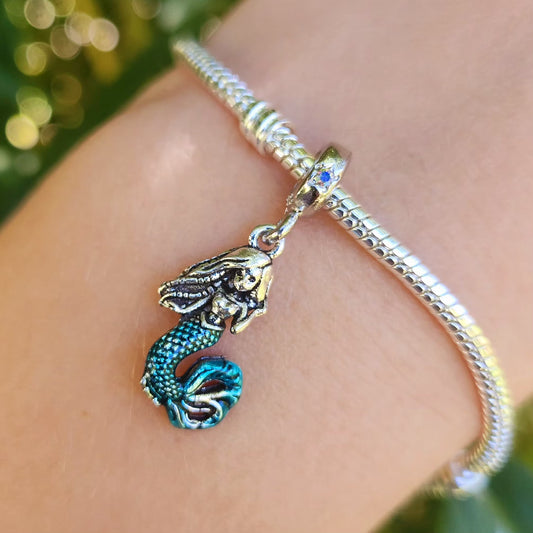 Plongez dans l'univers enchanteur d'Ariel avec ce magnifique pendentif inspiré par la célèbre princesse de La Petite Sirène. Confectionné en argent sterling S925, ce pendentif allie élégance et qualité, capturant avec finesse la beauté et la grâce de la célèbre sirène.

Ce pendentif est un ajout idéal pour toute collection, notamment pour les amateurs des contes de Disney. Il se marie parfaitement avec les bracelets Pandora et autres chaînes pour créer un look personnel et enchanteur.

Chaque pièce est soig