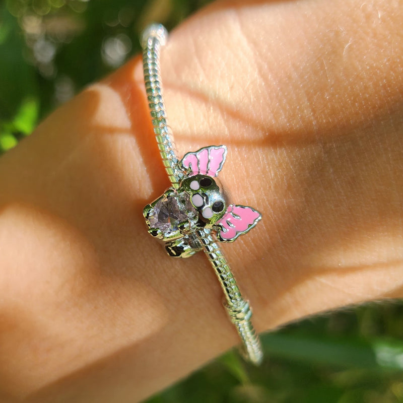 Ce charm aquatique adorable affiche une petite salamandre grise aux branchies roses vives déployées comme pétales, yeux noirs ronds joyeux et bouche souriante timide, serrant un cœur rose cristallin entre ses pattes. La queue effilée et texture lisse renforcent le charme mignon du pendentif suspendu. Symbole de tendresse sous-marine et douceur mystérieuse, il aquatise les bracelets d'une vague de câlins pétillants.

Caractéristiques

Matière : Argent 925 avec émail gris rose et cristal cœur rose.
Design : A