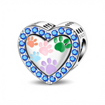 Ce charm en forme de cœur argenté met à l’honneur l’amour des animaux avec plusieurs empreintes de pattes colorées au centre. Le contour du cœur est entièrement serti de cristaux bleus éclatants, créant un effet lumineux qui fait ressortir la surface miroir du cœur et ses motifs pastel.
