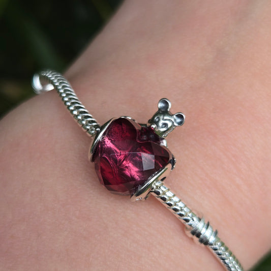 Ajoutez une touche d'amour et de magie Disney à votre bracelet avec ce charm en forme de cœur, délicatement orné de la silhouette emblématique de Mickey Mouse. Fabriqué en argent sterling 925, ce charm capture l'esprit enchanteur de Disney tout en apportant une note d'élégance et de tendresse. Parfait pour les fans de Mickey et de l'univers Disney, ce charm est une manière idéale de personnaliser votre bracelet avec une touche de fantaisie et de nostalgie.