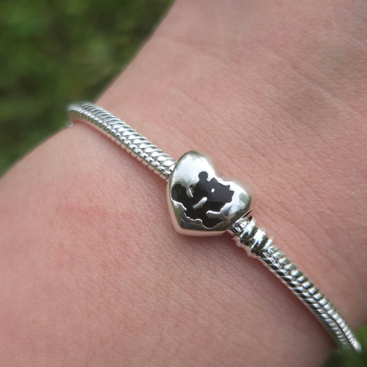 Ajoutez une touche de romance et de magie à votre collection avec ce charm en forme de cœur représentant Mickey et Minnie, les célèbres personnages de Disney. Fabriqué en argent sterling 925, ce charm de haute qualité est compatible avec tous les bracelets Pandora, garantissant une intégration parfaite à votre bijou préféré. Parfait pour les fans de Mickey, Minnie et de l'univers Disney, ce charm capture l'amour éternel et l'esprit joyeux de ce couple emblématique avec des détails minutieusement travaillés,