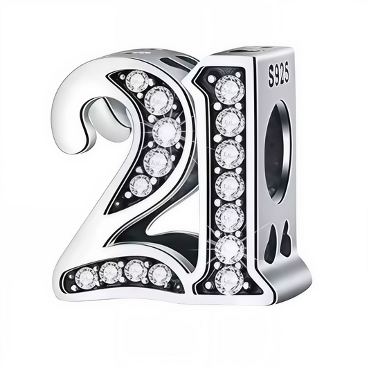 Ajoutez une touche d’éclat à votre bracelet avec ce charm en forme de chiffre "21", réalisé en argent 925 et orné de strass scintillants. Un bijou élégant et raffiné, idéal pour célébrer un anniversaire ou un moment spécial avec style.
