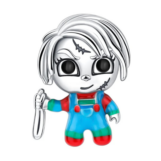 Apportez une touche effrayante et captivante à votre collection avec ce charm inspiré de Chucky, l’iconique poupée de l’horreur. Fabriqué en métal argenté et noirci, avec des accents émaillés rouges et bleus, ce charm capture l’expression sinistre et le look reconnaissable du personnage. Détails de la cicatrice, des cheveux et de sa salopette sont minutieusement sculptés, rendant hommage à ce classique du cinéma d’horreur. Idéal pour les fans de thrillers et de culture pop, ce charm est compatible avec les 