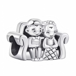 Ce charm en argent 925 représente un adorable couple assis côte à côte sur un canapé, serré l’un contre l’autre, symbole de complicité et d’amour au quotidien. Les deux personnages sont finement détaillés : visage souriant, vêtements stylisés et accoudoirs du canapé aux courbes douces, pour un résultat à la fois ludique et attendrissant.