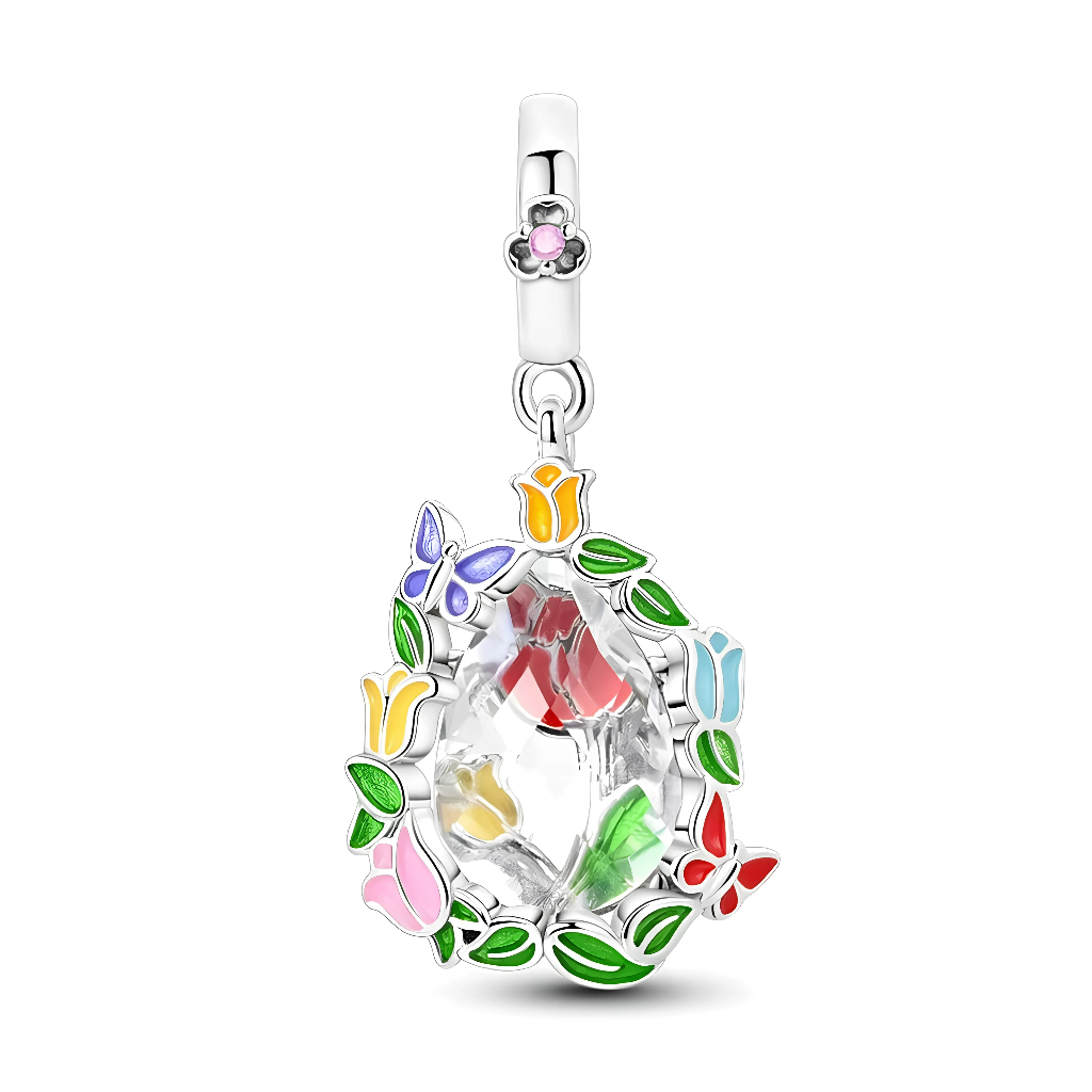 Ce charm pendant en argent 925 met en valeur un grand cristal transparent facetté, entouré d’une couronne de feuilles émaillées vertes, de fleurs multicolores et de petits papillons rouges, bleus et violets. La bélière lisse est ornée d’une mini fleur rose sertie en son centre, ajoutant une touche délicate à cet ensemble très printanier.

Caractéristiques :

-Matière : Argent 925 avec cristal transparent et émaux colorés.
-Design : Grosse pierre centrale cerclée de feuilles, tulipes et papillons, bélière dé