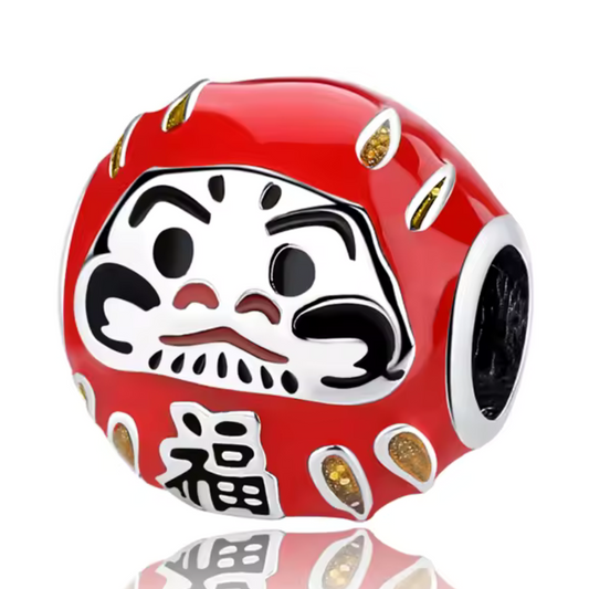 Célébrez la prospérité et la détermination avec ce charm représentant un Daruma rouge, symbole japonais de chance et de persévérance. Fabriqué en argent sterling S925, ce charm est orné de détails raffinés qui capturent l'essence du célèbre porte-bonheur japonais. Le Daruma est un symbole de succès et de bonne fortune, parfait pour accompagner vos objectifs et vos rêves. Compatible avec les bracelets Pandora, il apportera une touche culturelle et porteuse de sens à votre collection.