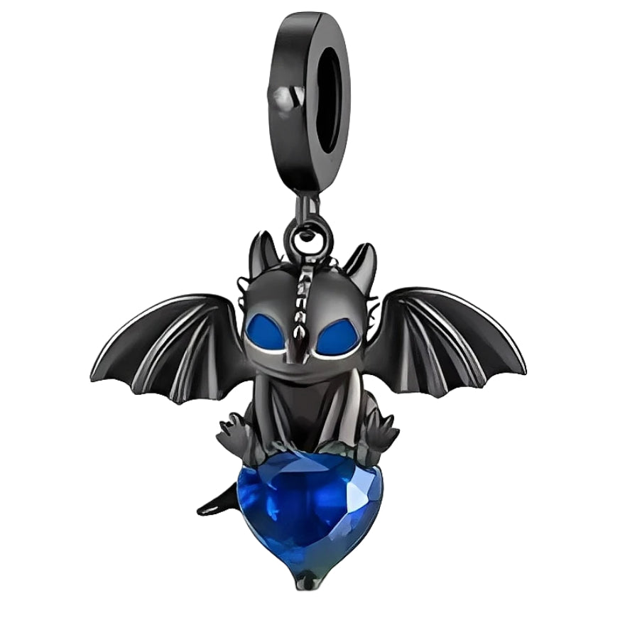 Ce charm pendant en métal noirci représente un petit dragon au style cartoon, ailes déployées et grands yeux bleus intenses. Assis, il enlace un cœur en cristal bleu facetté qui capte la lumière à chaque mouvement, apportant une touche à la fois mystérieuse et tendre au bracelet.

Caractéristiques :
Matière : Alliage métal noirci avec cristal synthétique bleu.
Design : Petit dragon ailé tenant un cœur facetté, suspendu à une bélière lisse.
Coloris : Noir graphite, bleu saphir lumineux.
Compatibilité : Convi
