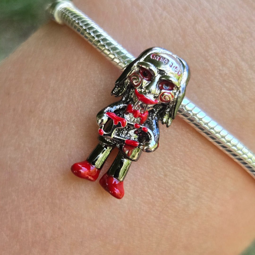 Apportez une touche d’originalité et de mystère à votre collection avec ce charm unique représentant Jigsaw tenant sa scie emblématique, inspiré de l’univers culte de la saga Saw. Ce design marquant et détaillé capture l’esprit intrigant et l’intensité du personnage, parfait pour les fans de films d’horreur ou pour ajouter une note audacieuse à vos bijoux.

Fabriqué en argent 925, ce bijou se distingue par ses finitions soignées et son allure captivante. Les détails précis du masque iconique et de la scie e